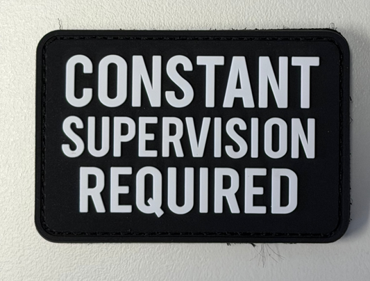 Black patch with white text 'CONSTANT SUPERVISION REQUIRED' on a light gray background